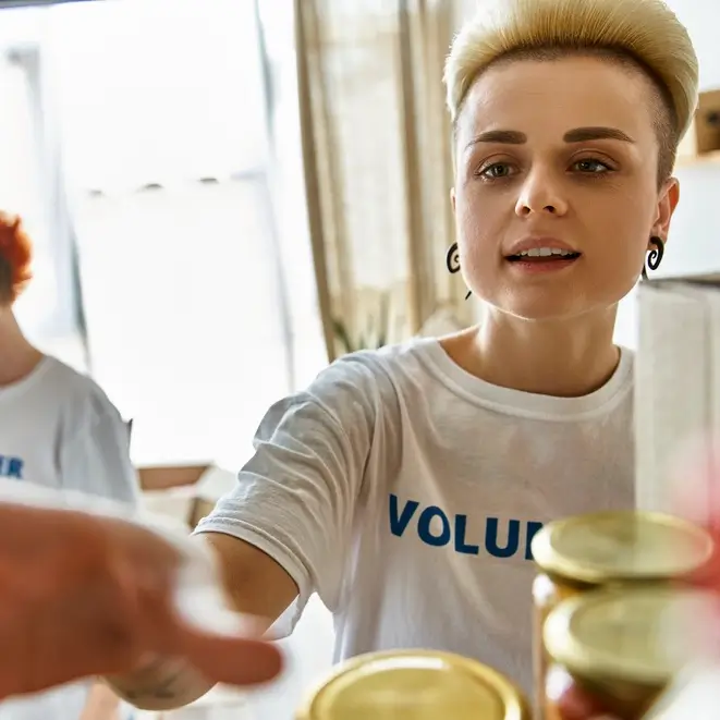 Volunteer grabbing a jar from a shelf.